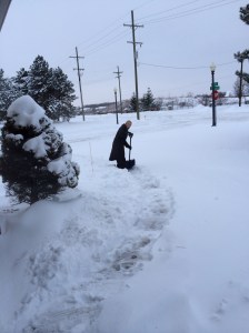 Tirando a neve da frente da garagem.